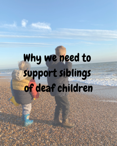 Two Young boys on beach throwing stones into the sea, one wearing hearing aids.